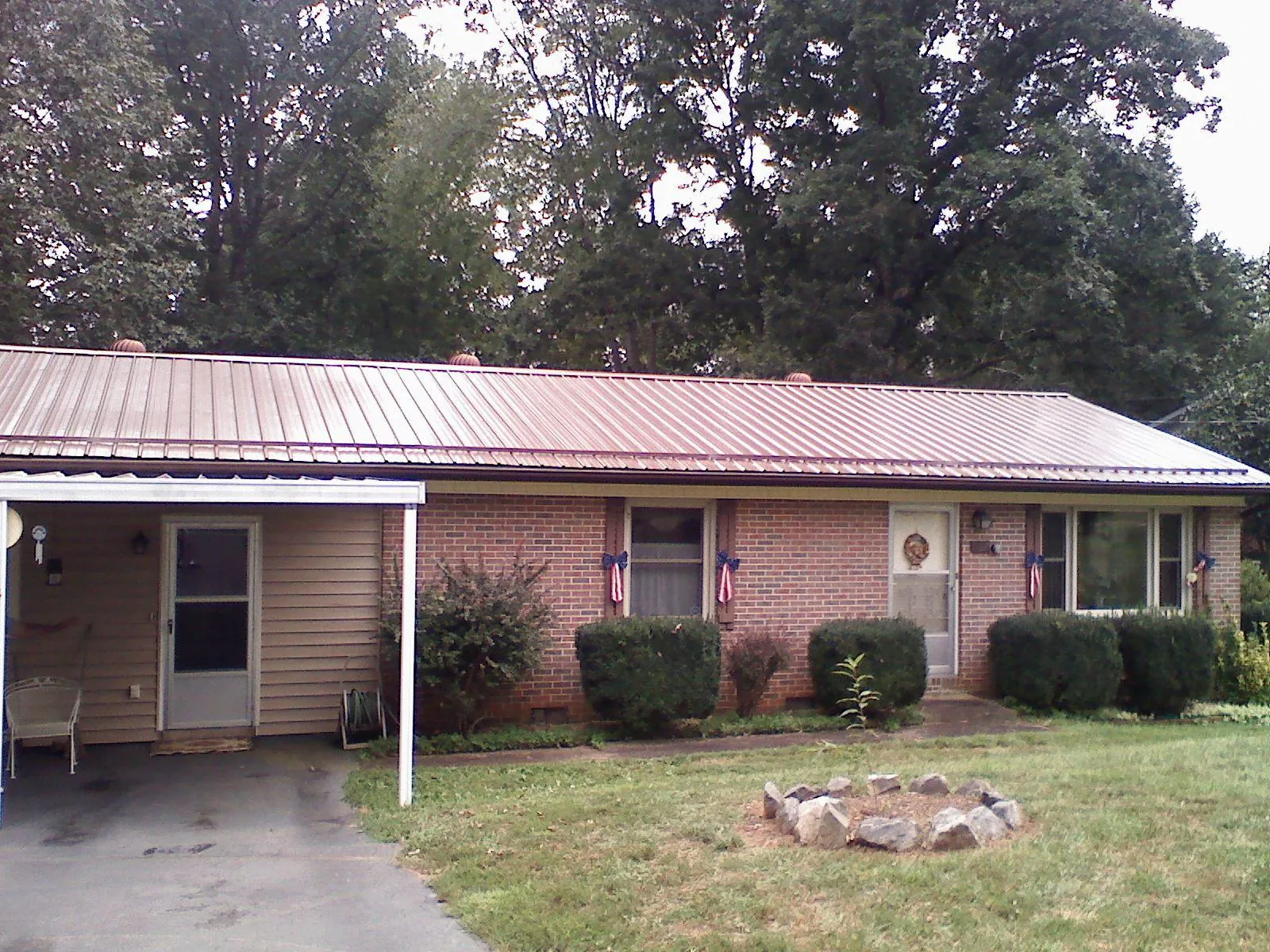 Bronze metal roof and carport on a brick ranch home — Roof Repair work by our crew in Parksley